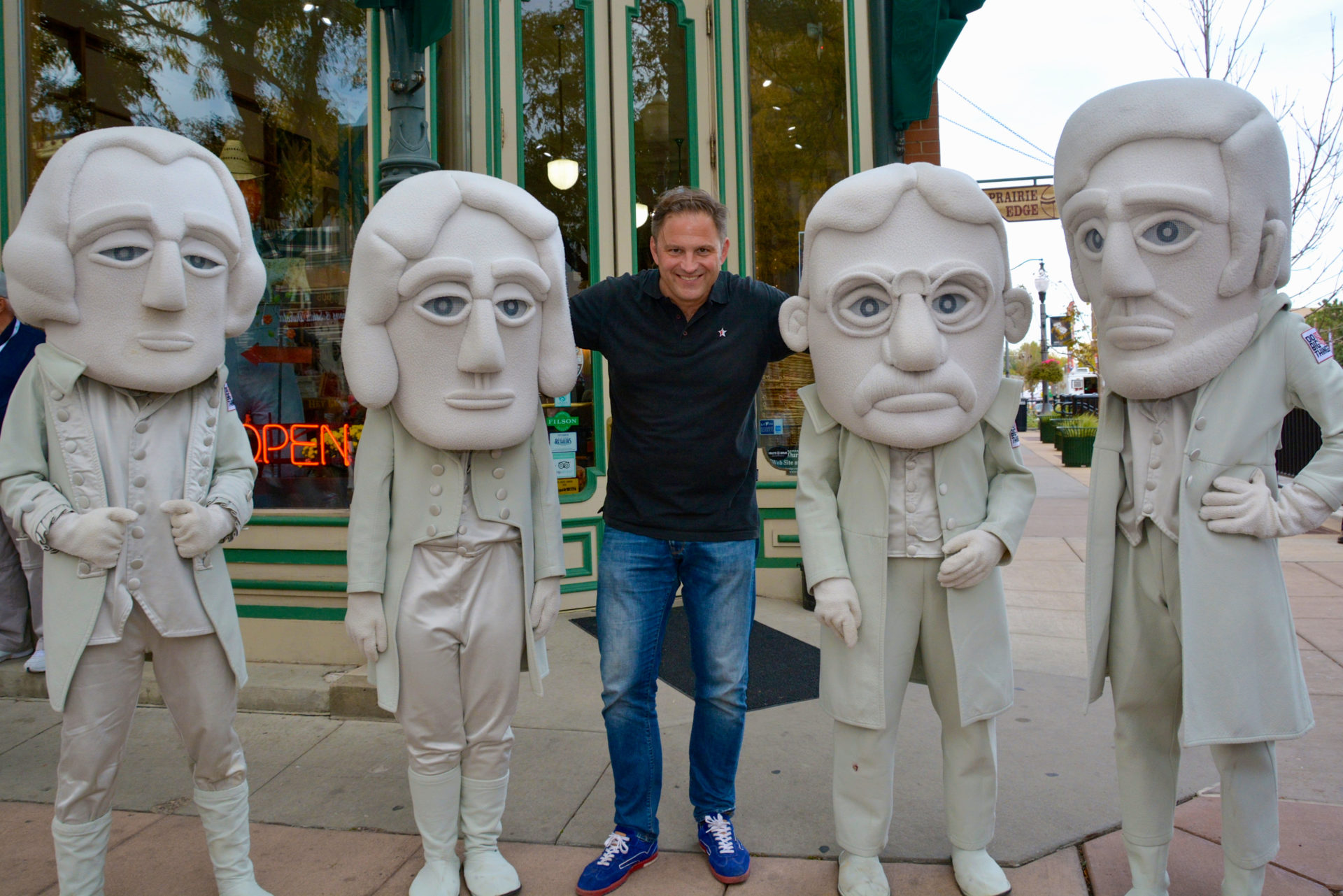 Autor Ralf Johnen mit Figuren des Präsidenten am Mount Rushmore