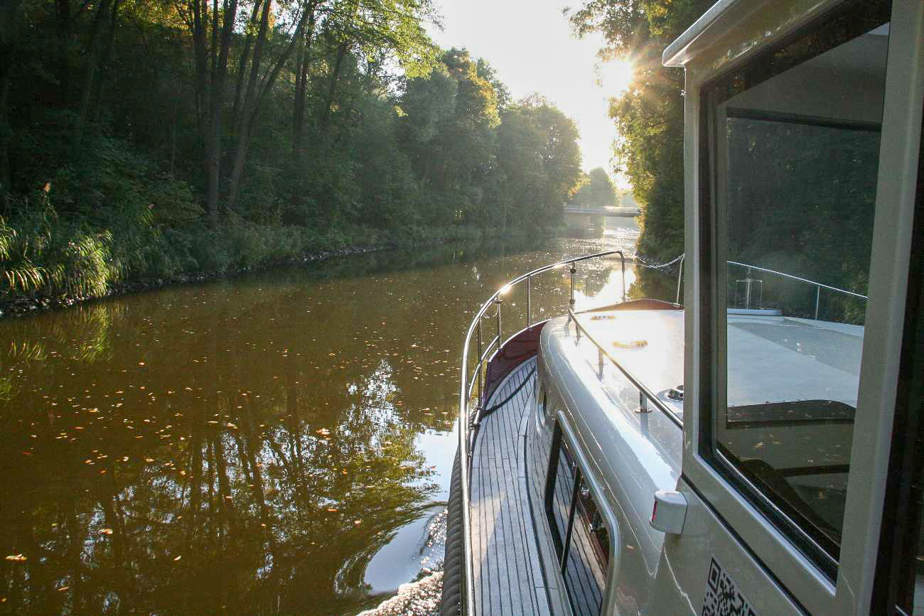 Hausboot fährt durch Kanal in Mecklenburg