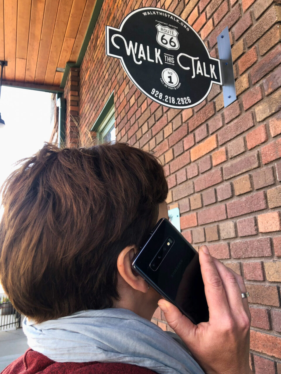 Frau mit Handy bei der Walk This Talk-Tour über die Route 66 in Flagstaff